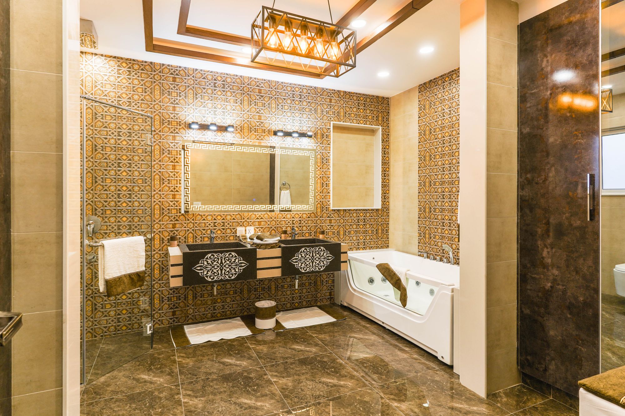 Upscale renovated bathroom with marble tile, modern bathtub, and warm lighting