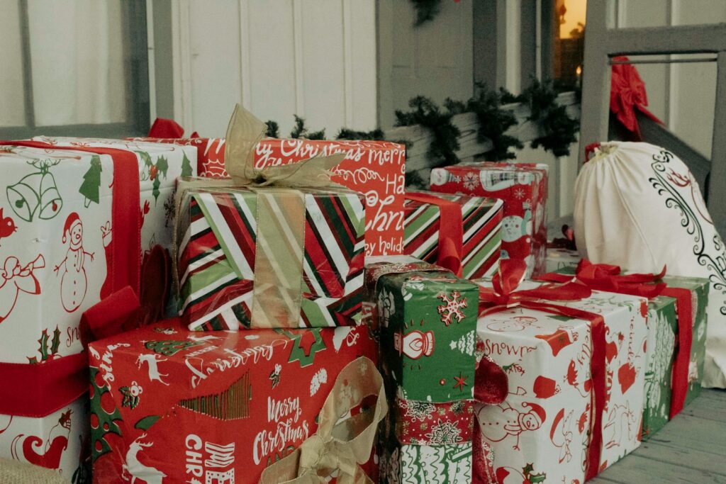 a pile of wrapped presents sitting on top of a wooden floor