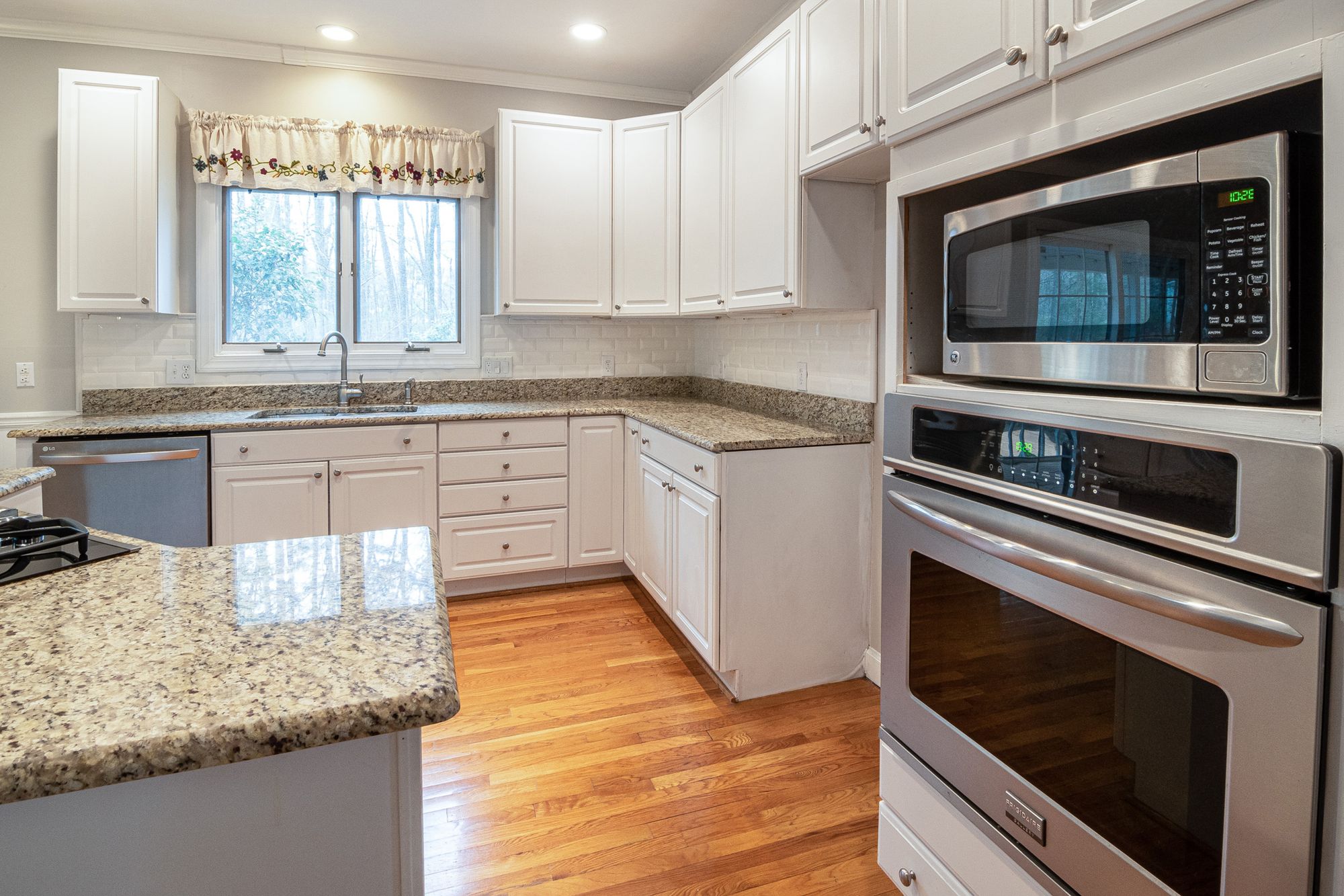 Modern kitchen with white cabinets and granite countertops, similar to settings where recalled countertop ovens are used