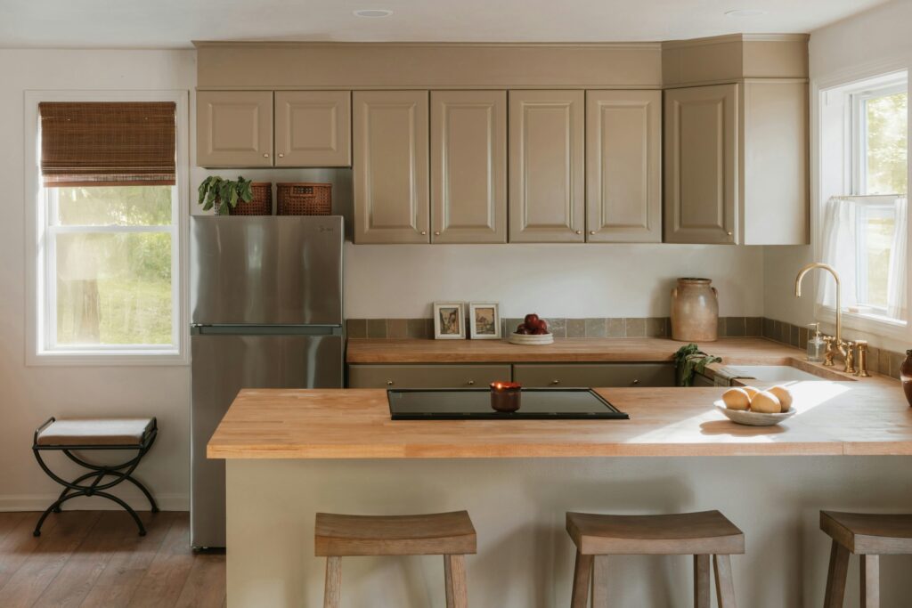Modern kitchen featuring light natural wood countertops and a matching wood island, reflecting the 2026 shift toward warm wood tones