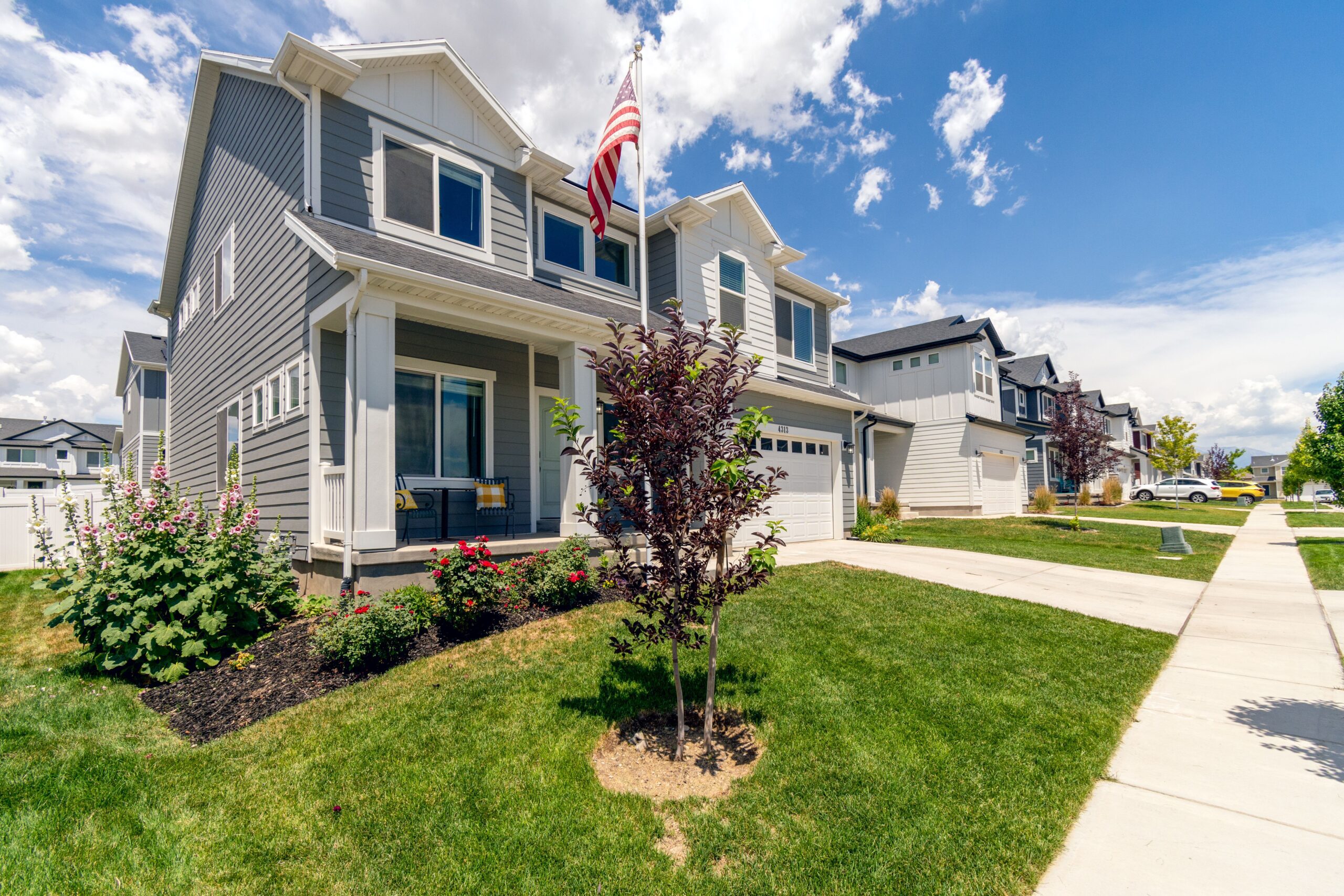 Modern suburban house with manicured landscaping and driveway, typical of an HOA-governed neighborhood
