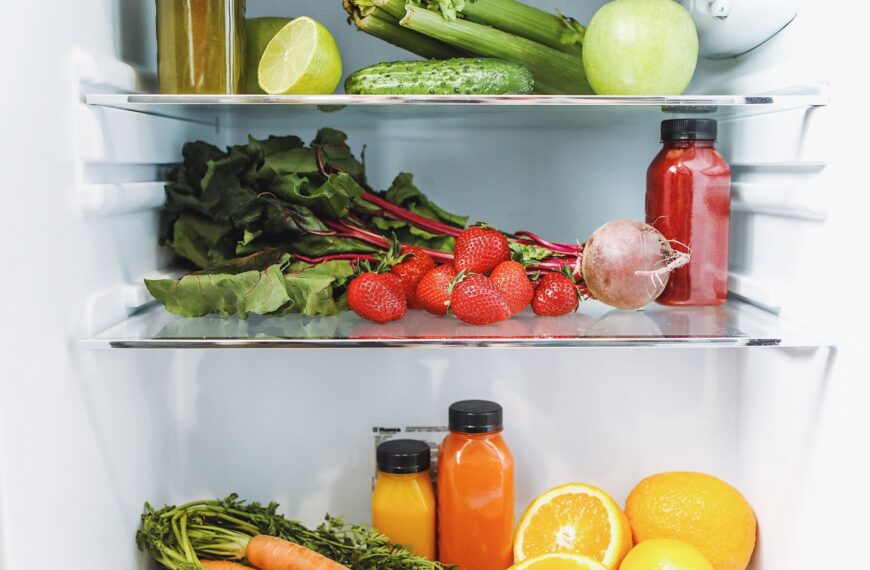 An organized refrigerator filled with colorful fresh fruits and vegetables