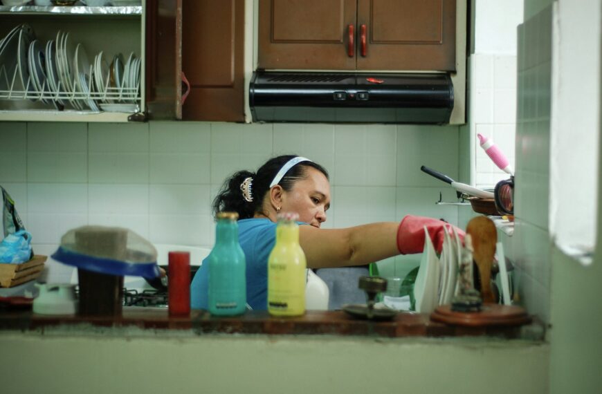 woman in white tank top holding white plastic container