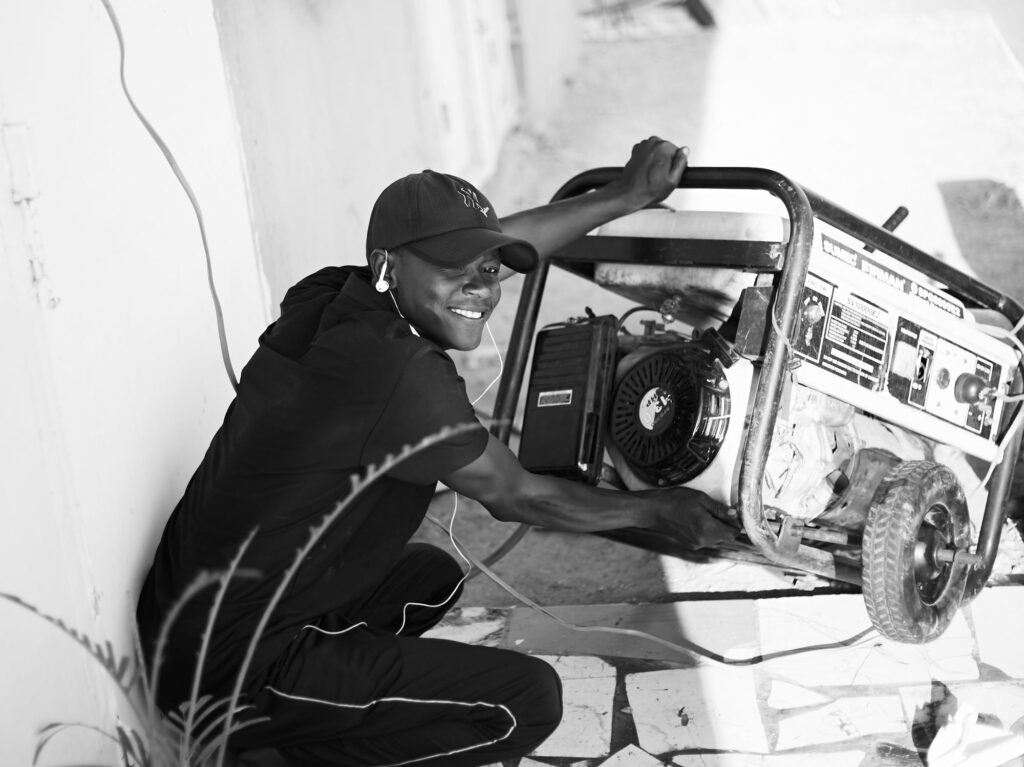 Man operating a portable generator outdoors, positioned away from the house to avoid carbon monoxide buildup