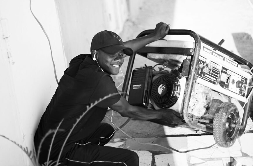 Man operating a portable generator outdoors, positioned away from the house to avoid carbon monoxide buildup