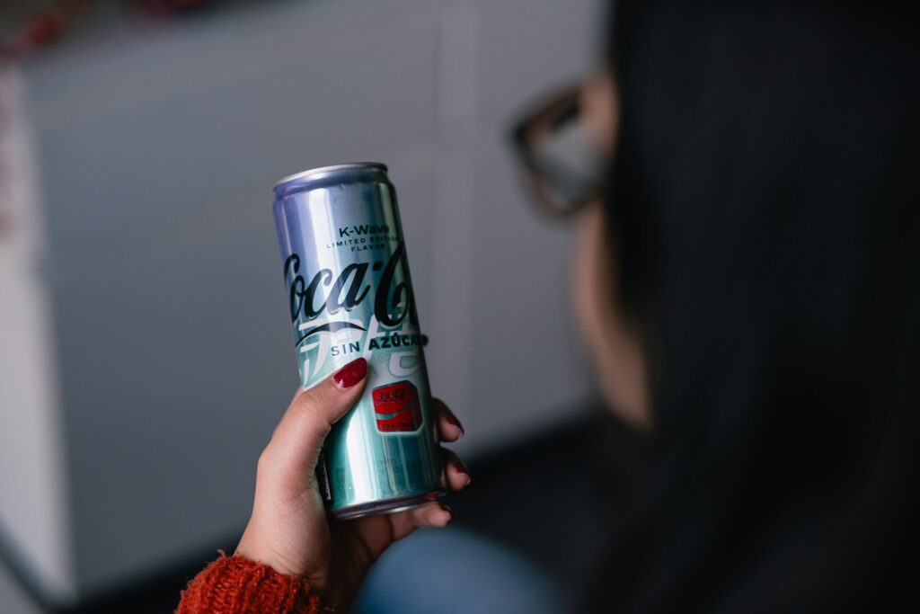 a woman holding a can of coca cola