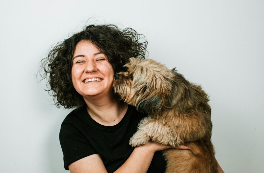 dog kissing woman in black crew-neck shirt