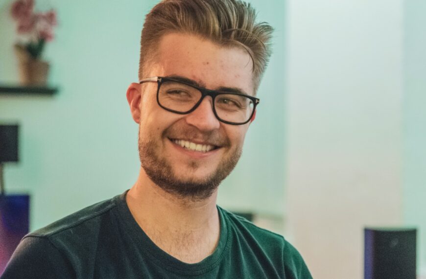 man wearing green crew-neck top and eyeglasses with black frames looking at side