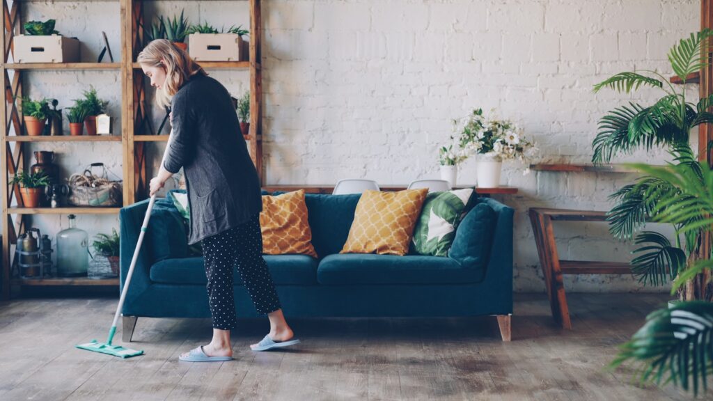 Woman cleaning the floor in a modern living room.