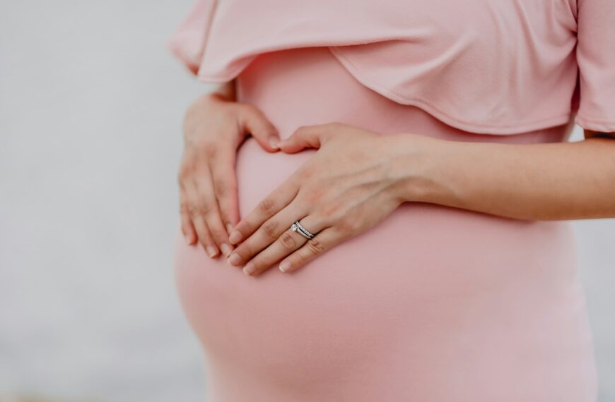woman wearing gold ring and pink dress
