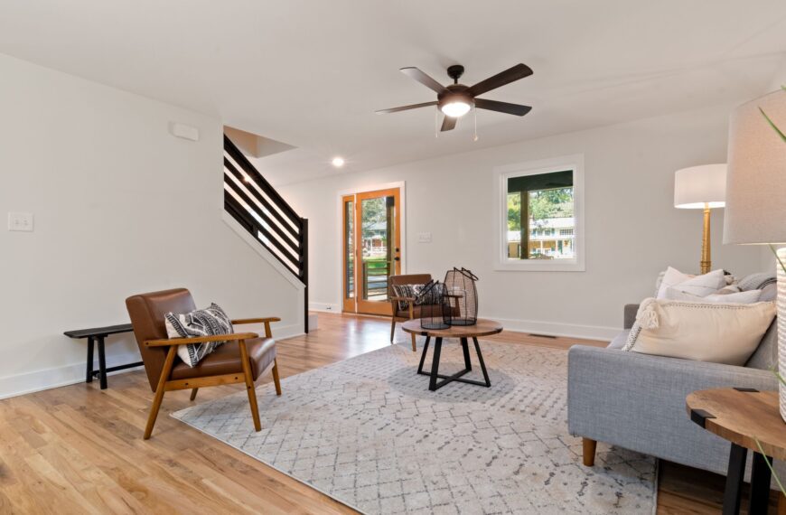 A bright, elegantly staged living room with neutral furnishings and natural light