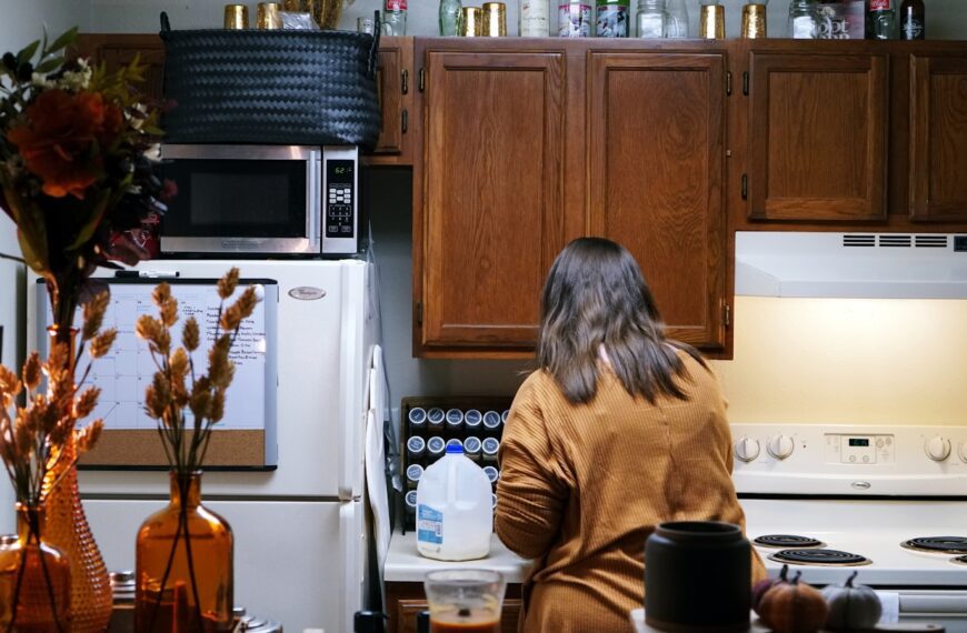 a woman standing in a kitchen next to a stove top oven