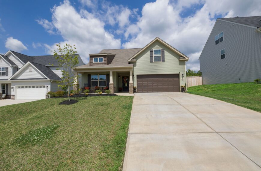 Bright modern suburban single-family house exterior with driveway and landscaping, representing a home subject to property taxes