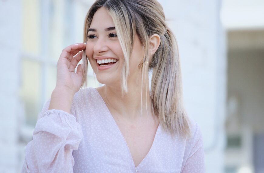 woman in white v neck long sleeve shirt smiling