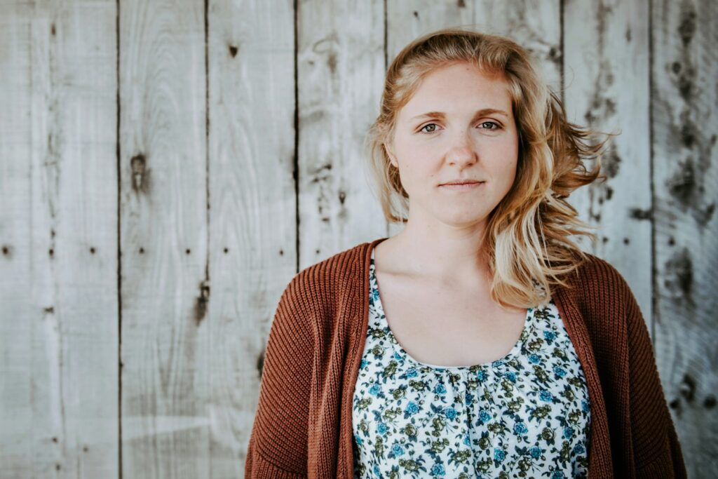 woman standing beside wooden wall