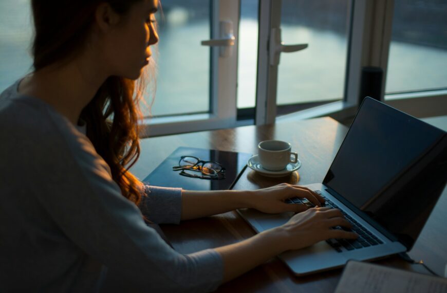 woman sitting beside table using laptop