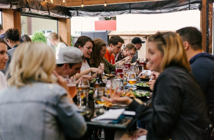 people sitting in front of table talking and eating