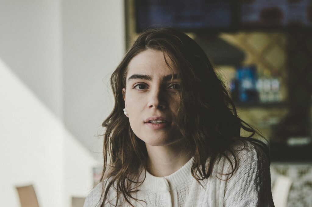 portrait photography of woman wearing knitted top