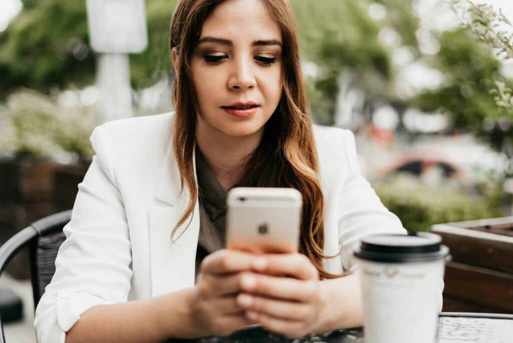 woman in white blazer holding white samsung android smartphone