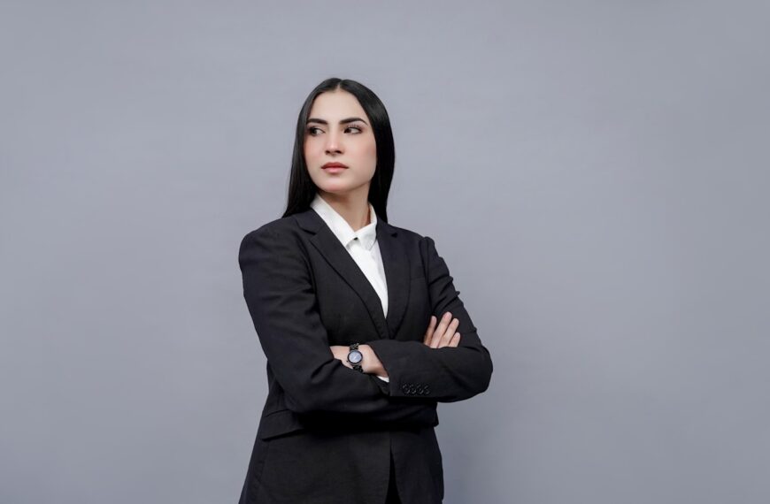 a woman in a business suit with her arms crossed