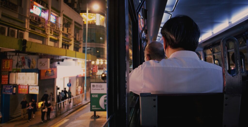 a man sitting on a bus looking out the window