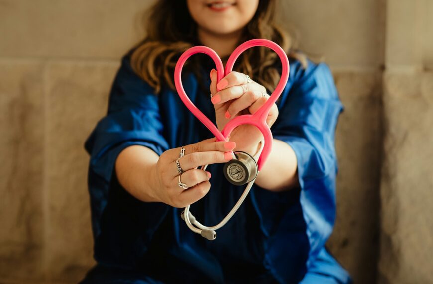 woman in scrubs holding heart shaped stethoscope