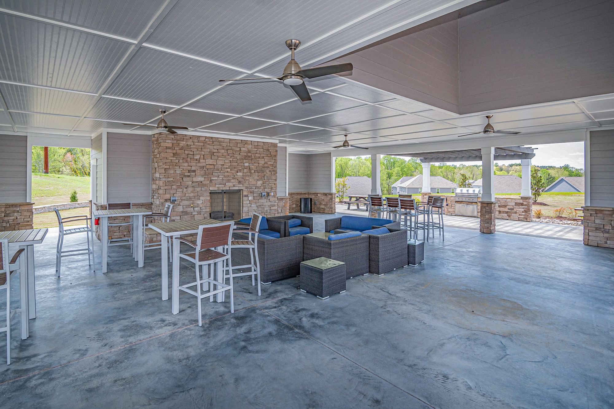 Backyard patio zoned into a lounge area with a sofa and a separate dining area with a wooden table and chairs