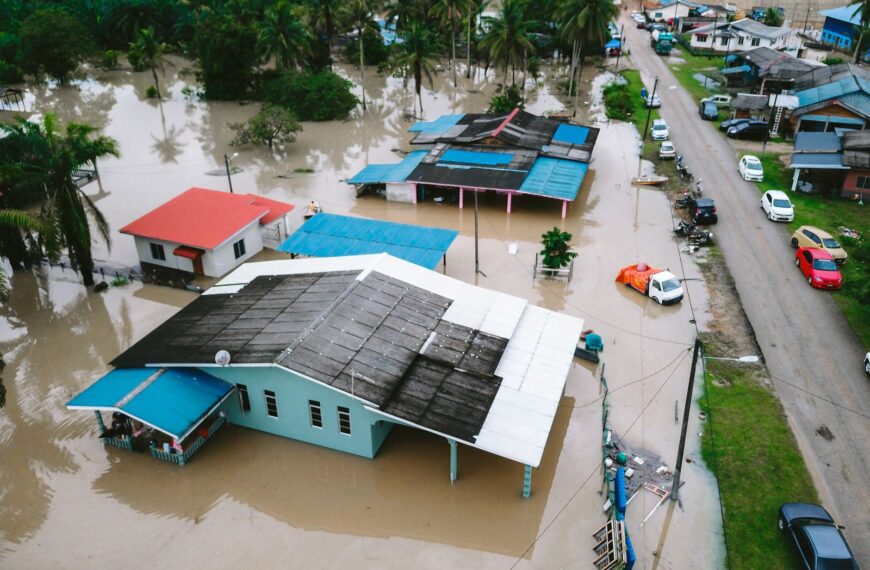 Aerial view of a flooded village in Kijal, Terengganu, Malaysia, showcasing submerged houses and streets.
