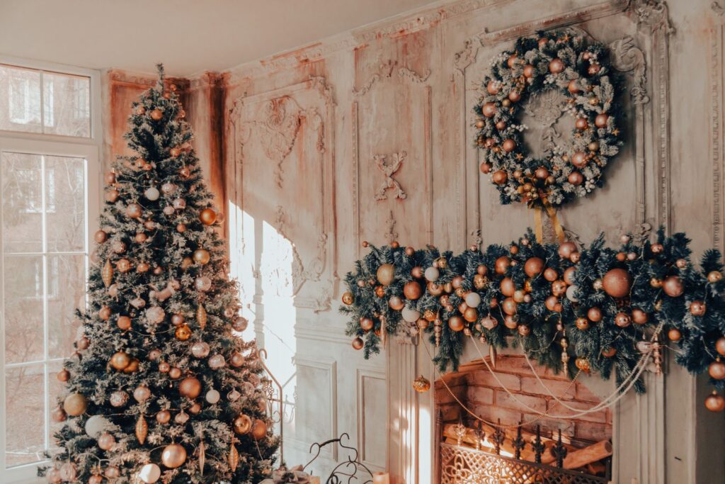 Cozy Christmas living room featuring a beautifully decorated tree, wreath, and fireplace garland.