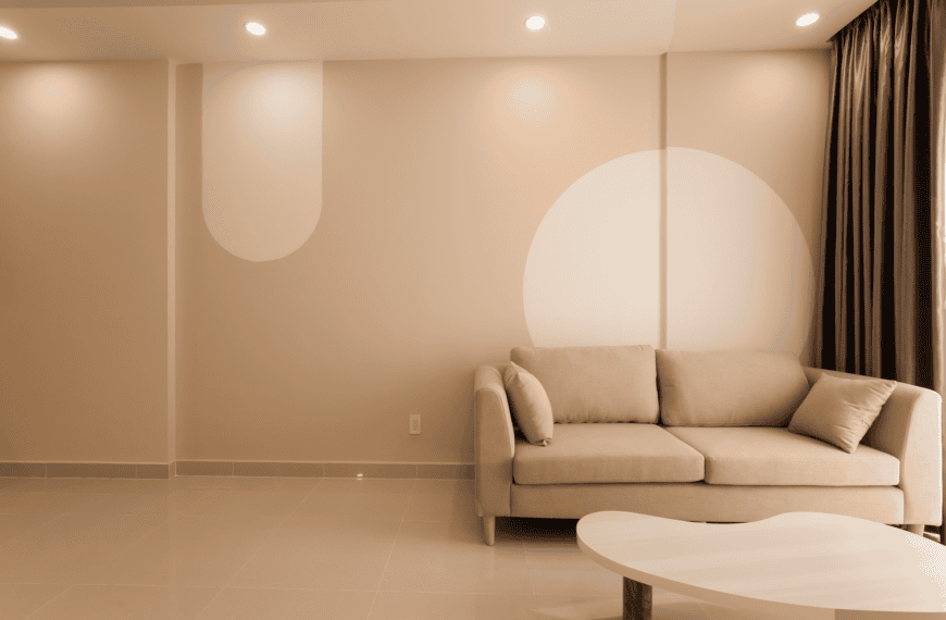 A cozy minimalist living room featuring a beige sofa, modern decor, and neutral tones for an inviting atmosphere.