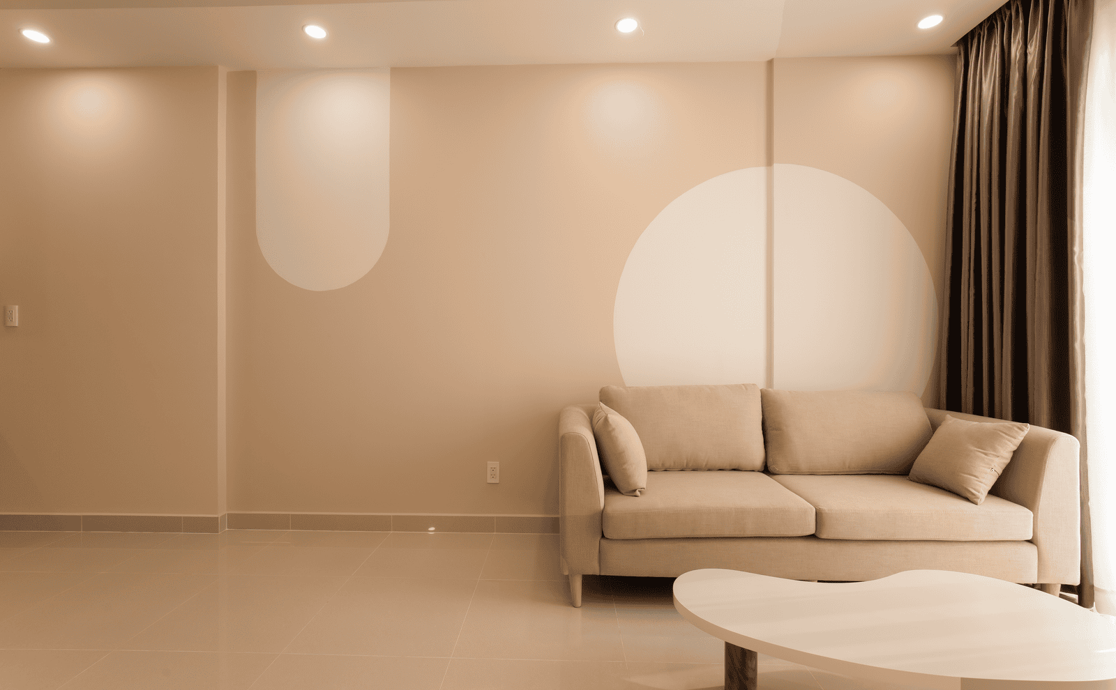 A cozy minimalist living room featuring a beige sofa, modern decor, and neutral tones for an inviting atmosphere.