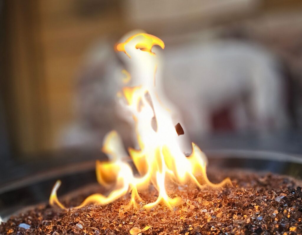 Mesmerizing close-up of flames dancing on a decorative outdoor fire pit.