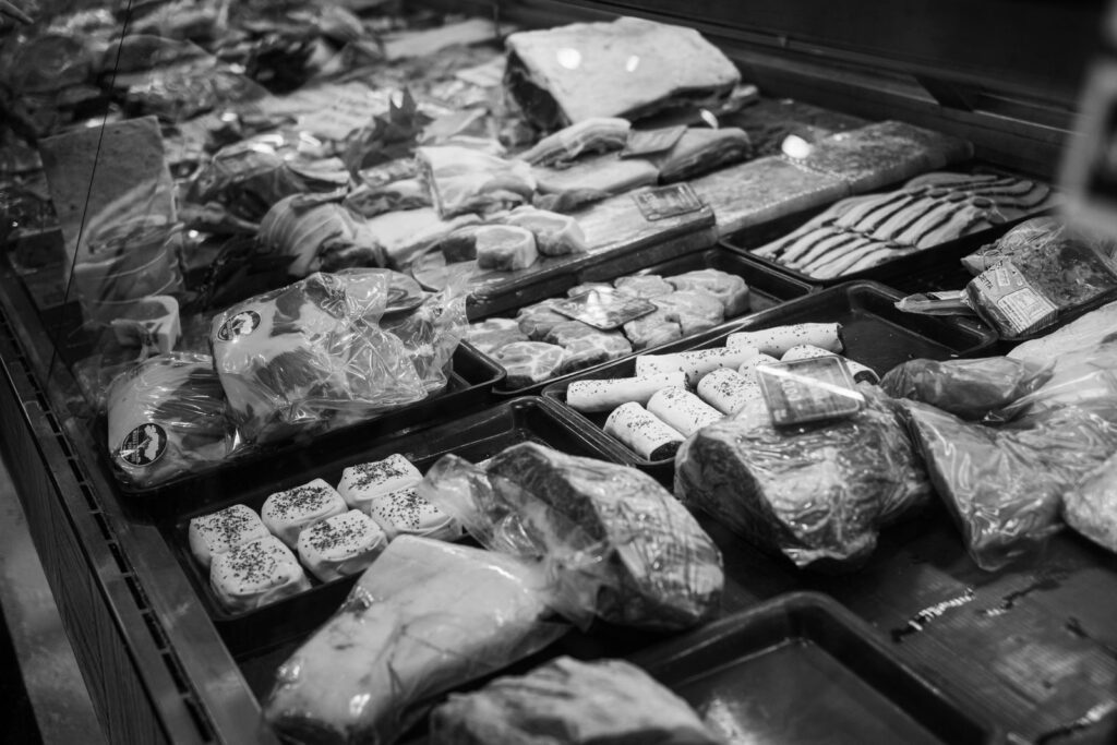 A monochrome butcher shop display featuring various packaged meats.