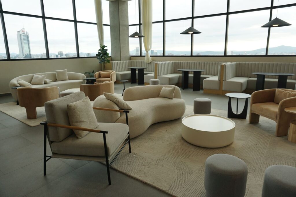 Spacious lounge featuring modern contemporary furniture with panoramic city view, ideal for meetings or relaxation.
