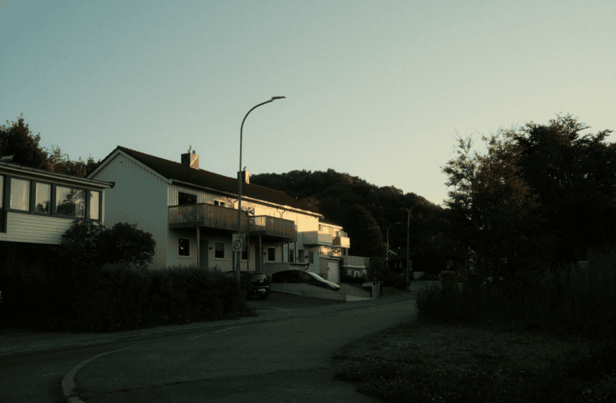 A serene twilight view of suburban houses on a quiet residential street.