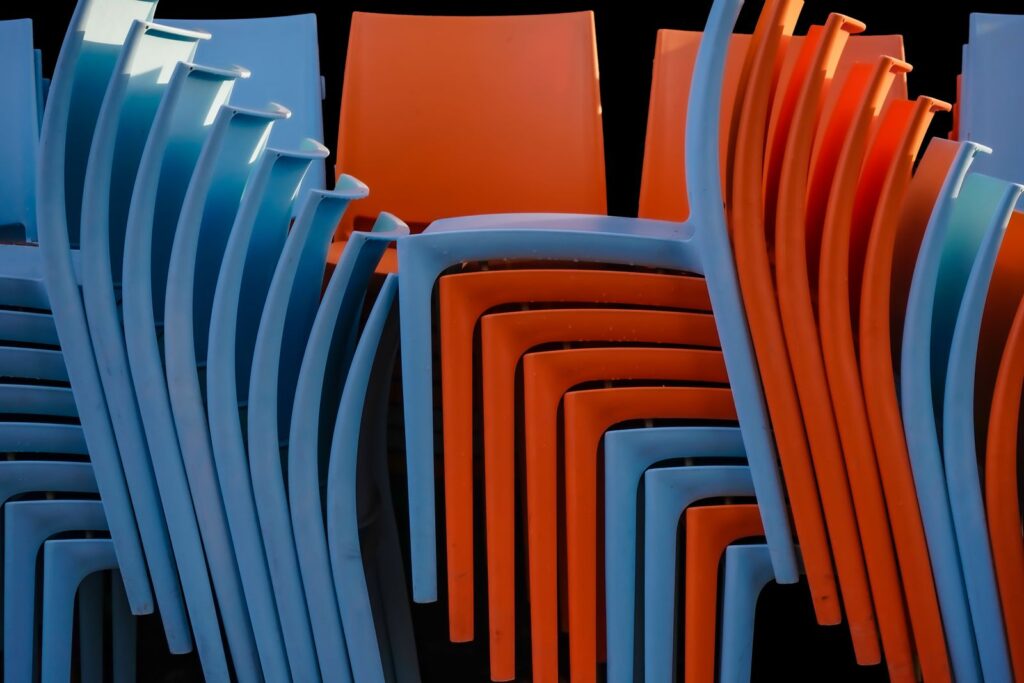 A vibrant stack of blue and orange chairs in an abstract pattern, creating an eye-catching contrast.