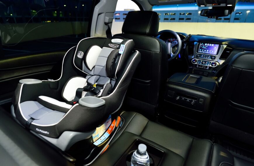 Interior of a car featuring a child safety seat and illuminated dashboard, captured at night.