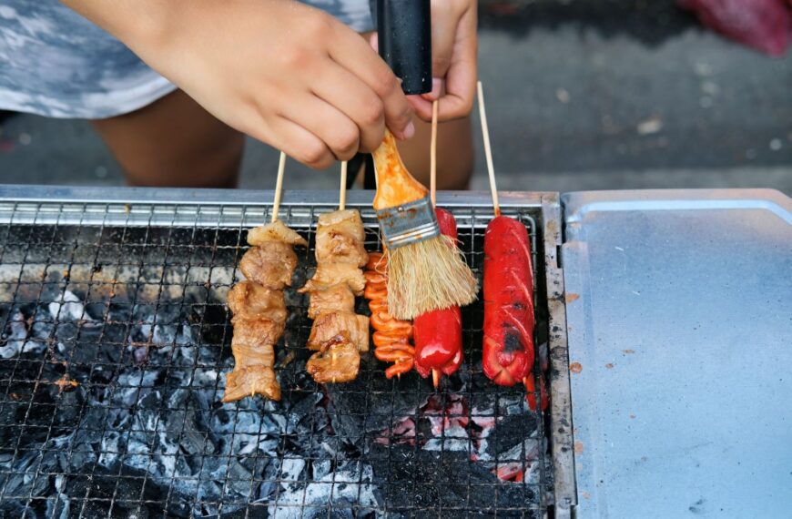 Authentic Filipino street food scene with a variety of grilled skewers sizzling over charcoal in Manila.