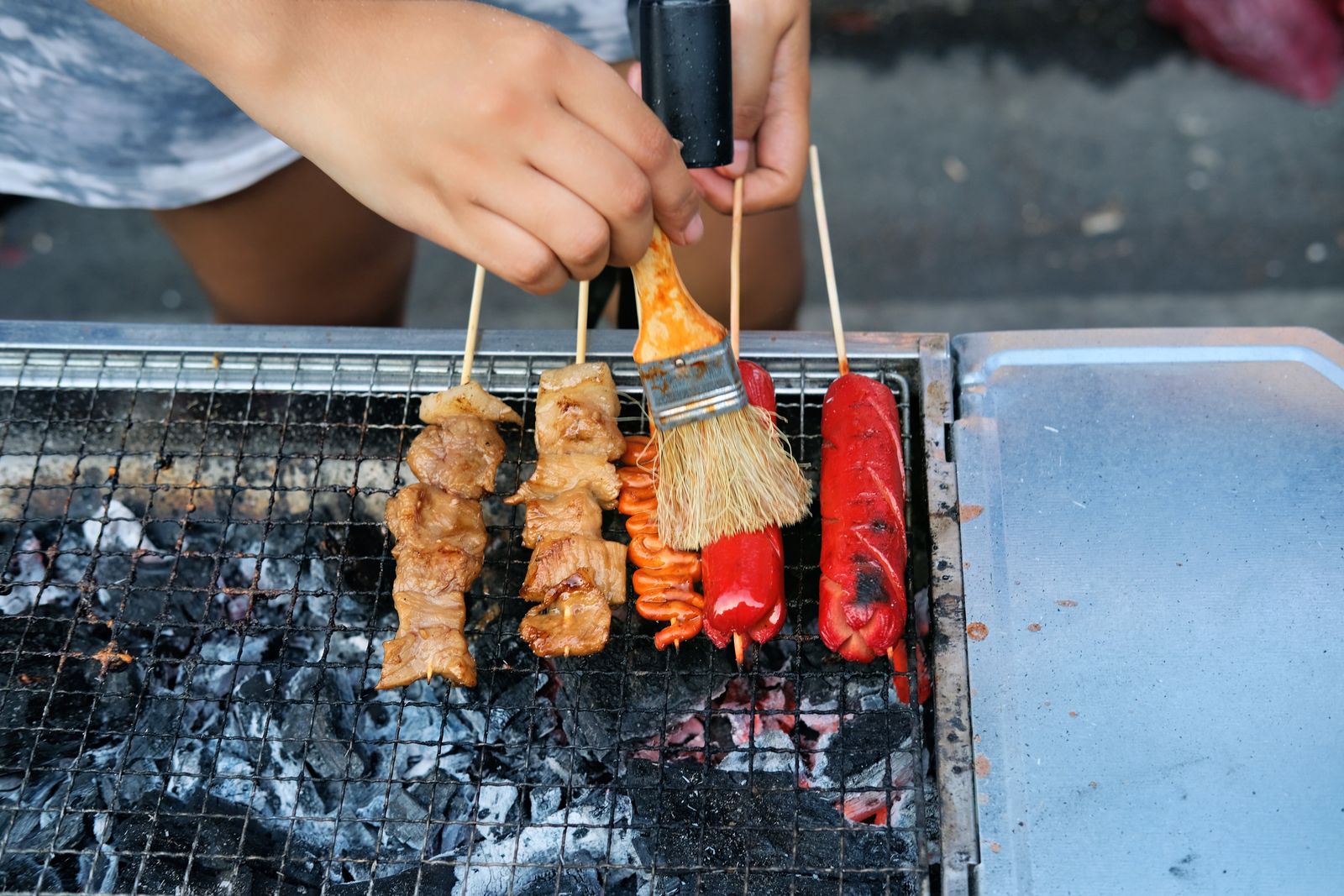 Authentic Filipino street food scene with a variety of grilled skewers sizzling over charcoal in Manila.