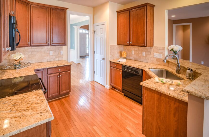 Bright kitchen interior with wooden cabinets and granite countertops.