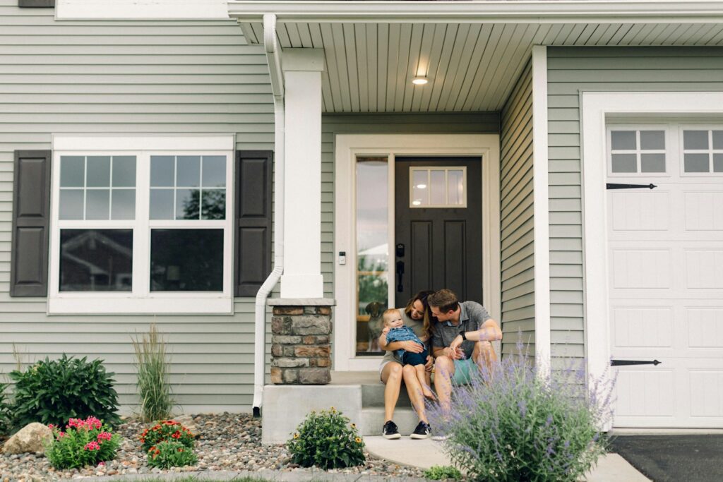 a couple of people that are sitting in front of a house