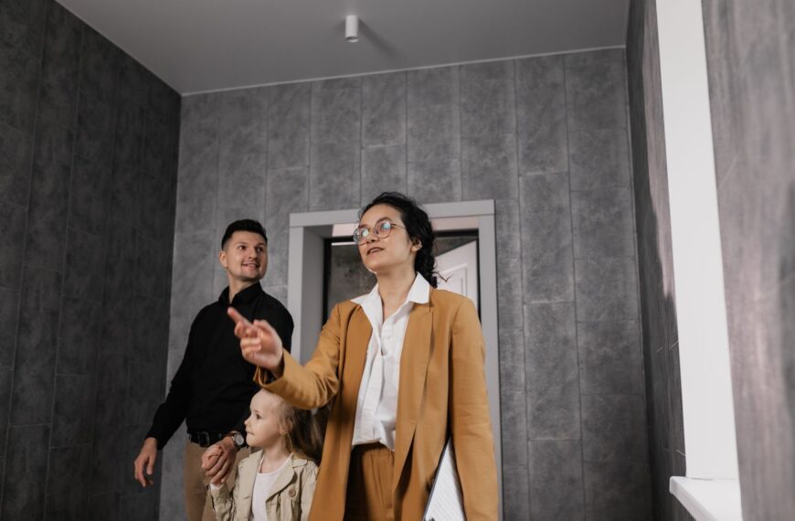 A family explores a modern home interior with a professional realtor guiding them.