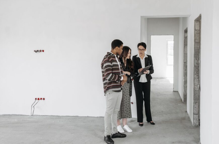 A couple and realtor discuss details in an unfinished property. Ideal for real estate themes.