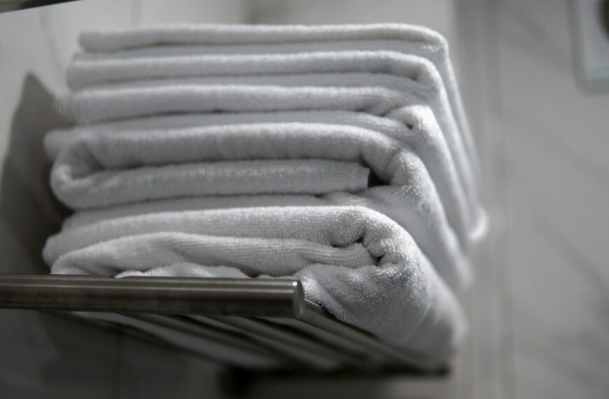 A stack of folded towels sitting on a towel rack