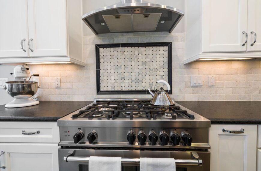Contemporary kitchen featuring a stainless steel stove and kettle with sleek cabinetry.