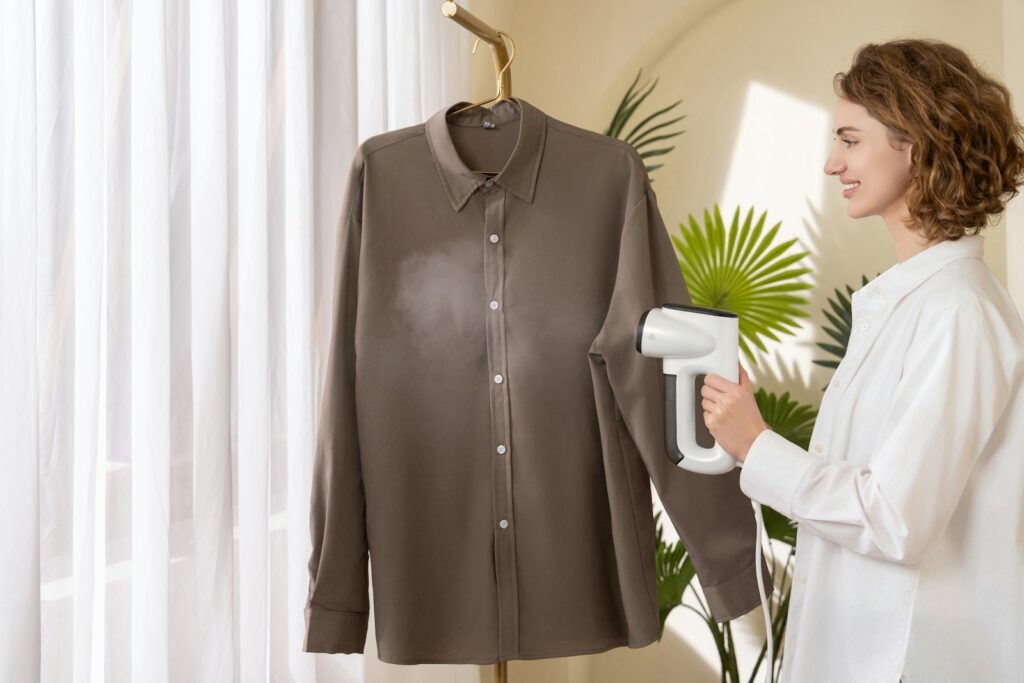A woman using a hair dryer to dry a shirt