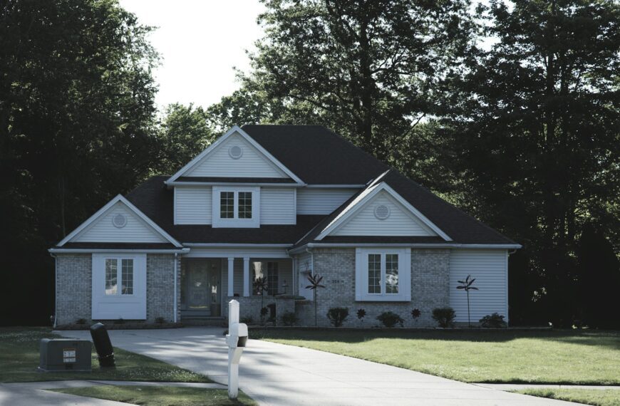 Modern suburban house with a green lawn and trees