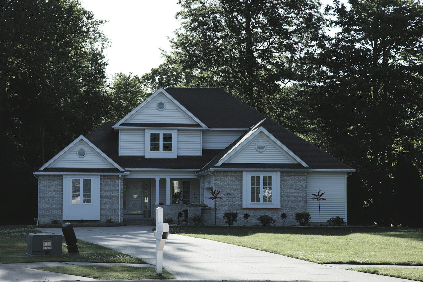 Modern suburban house with a green lawn and trees