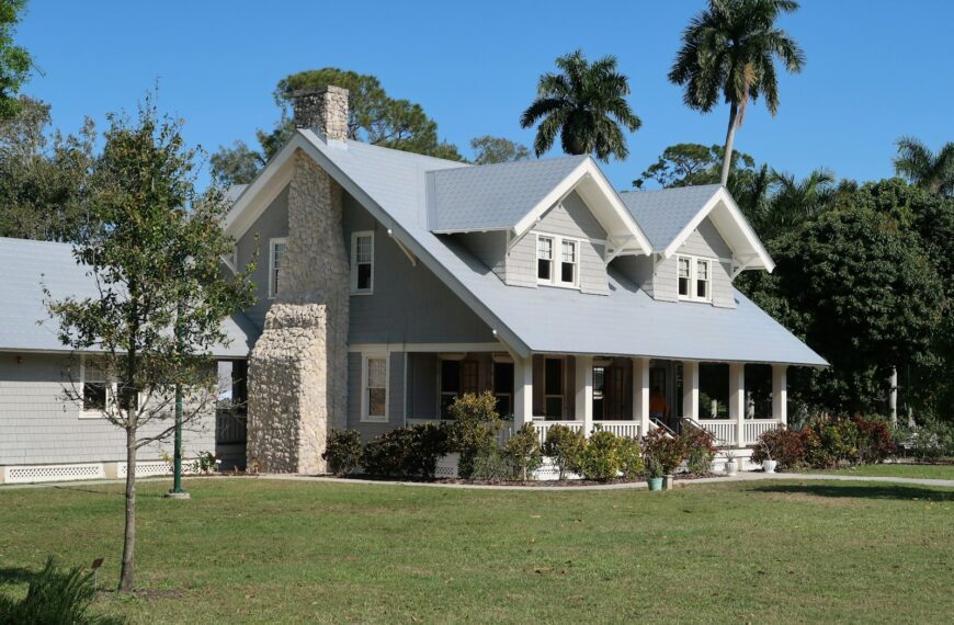 A grey house with a stone chimney and porch in Fort Myers, Florida