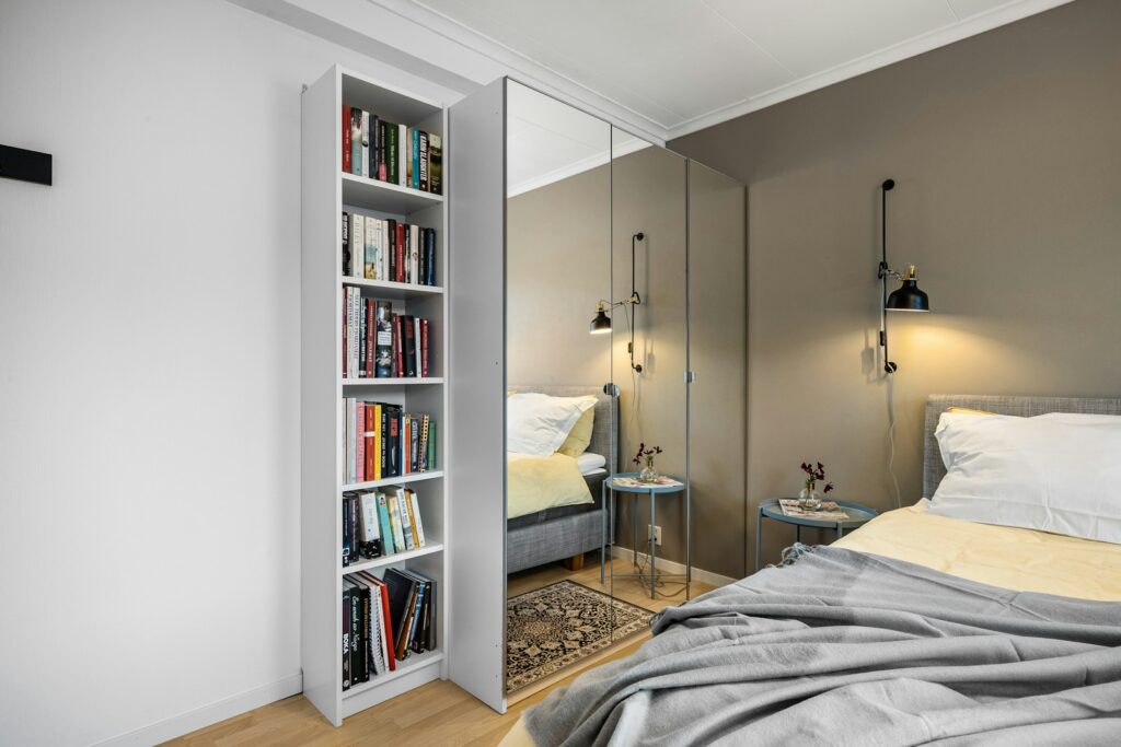 A bedroom with a bed and a book shelf